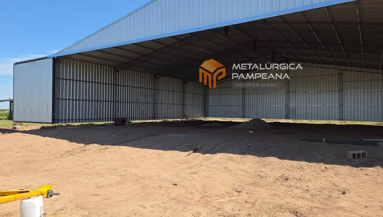 Interior y frente abierto del hangar con cuatro portones corredizos para ingreso de aeronaves